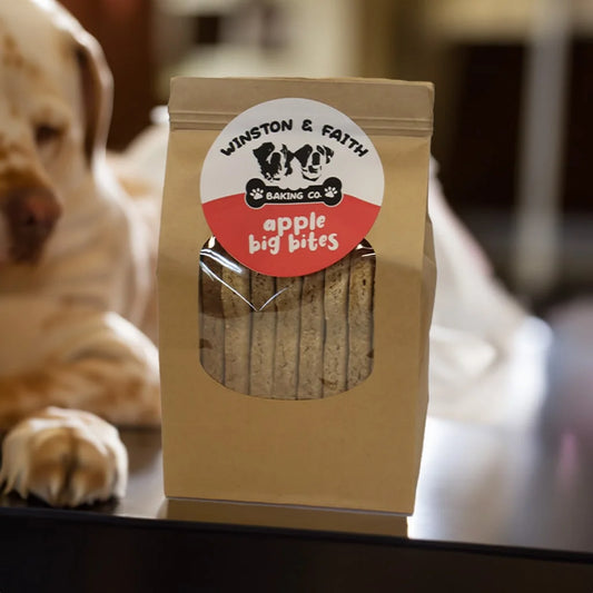 brown packaging bag with white and red dog treat label on the front. With a blurred dog in the background