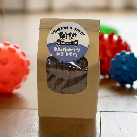 brown packaging with a white and blue label on teh front with dog toys in the background