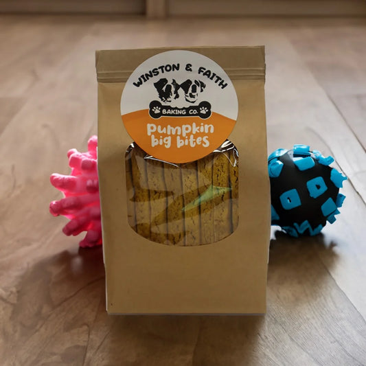 brown packaging bag with white and orange dog treat label on the front. With dog toys in the background.